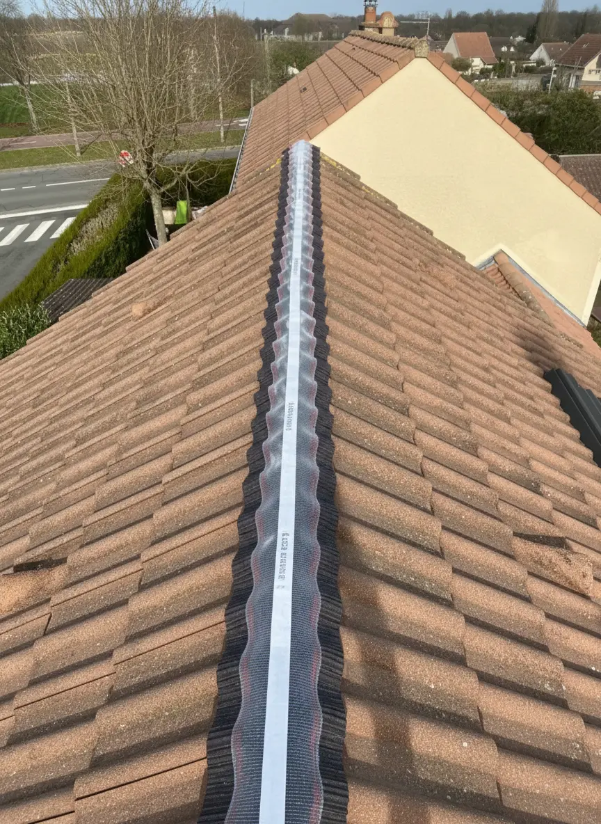 Pose d'un closoir ventilé souple sur le faîtage d'une toiture en tuiles. Solution d'étanchéité et de ventilation sous faîtière pour prévenir les infiltrations et l'humidité